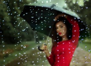 傘を広げる赤い服の女性