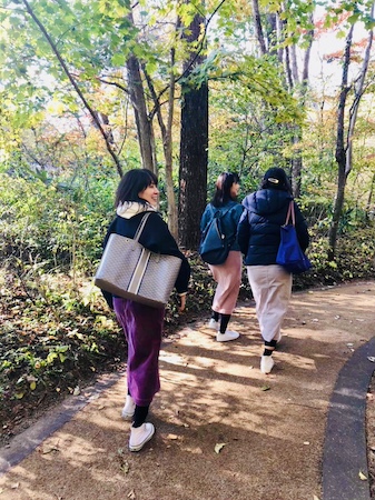 緑の中を歩く３人の後ろ姿