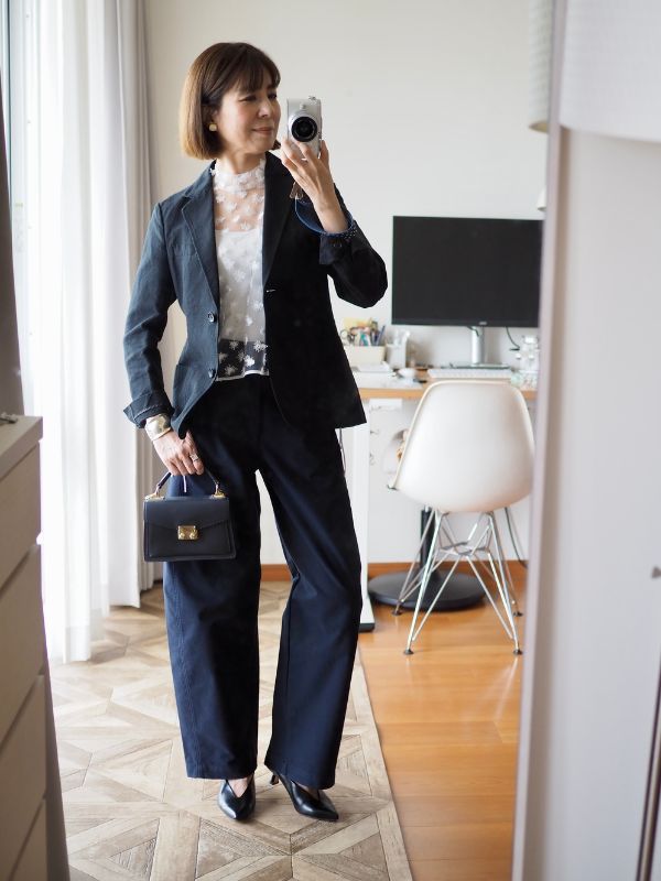 黒ジャケットのインナーにレースのブラウスの着画。